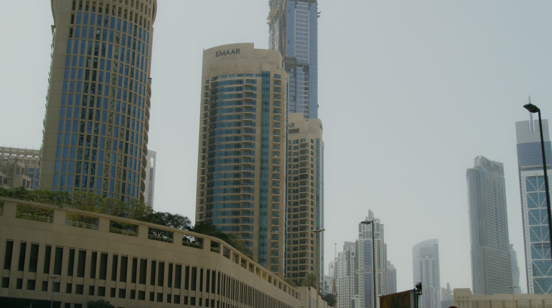 Wohncluster in Dubai International City in der Abenddämmerung, niedrige bis mittelhohe Apartmentgebäude entlang begrünter Innenhöfe