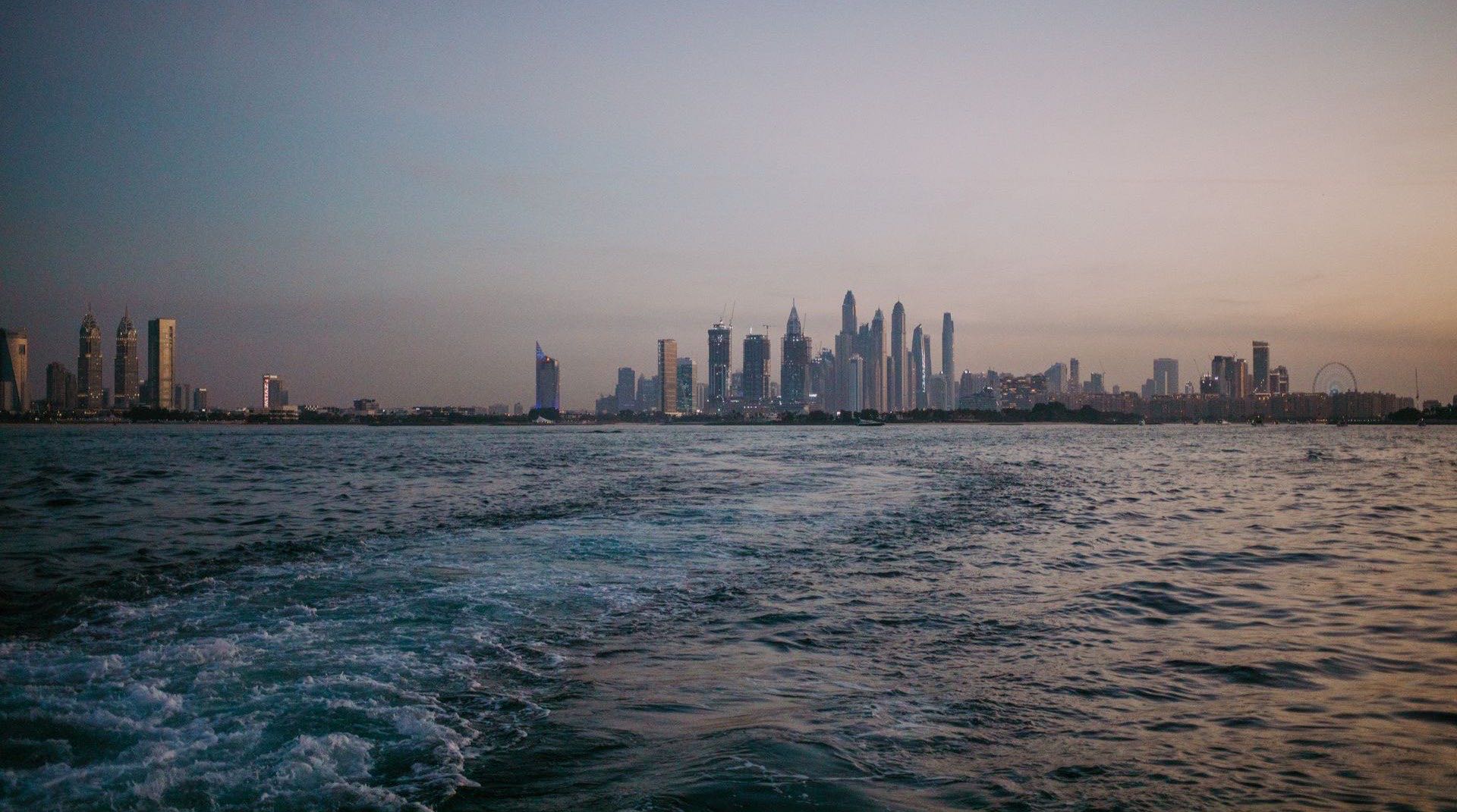 Skyline der Dubai Marina vom Meer aus in der Abenddämmerung