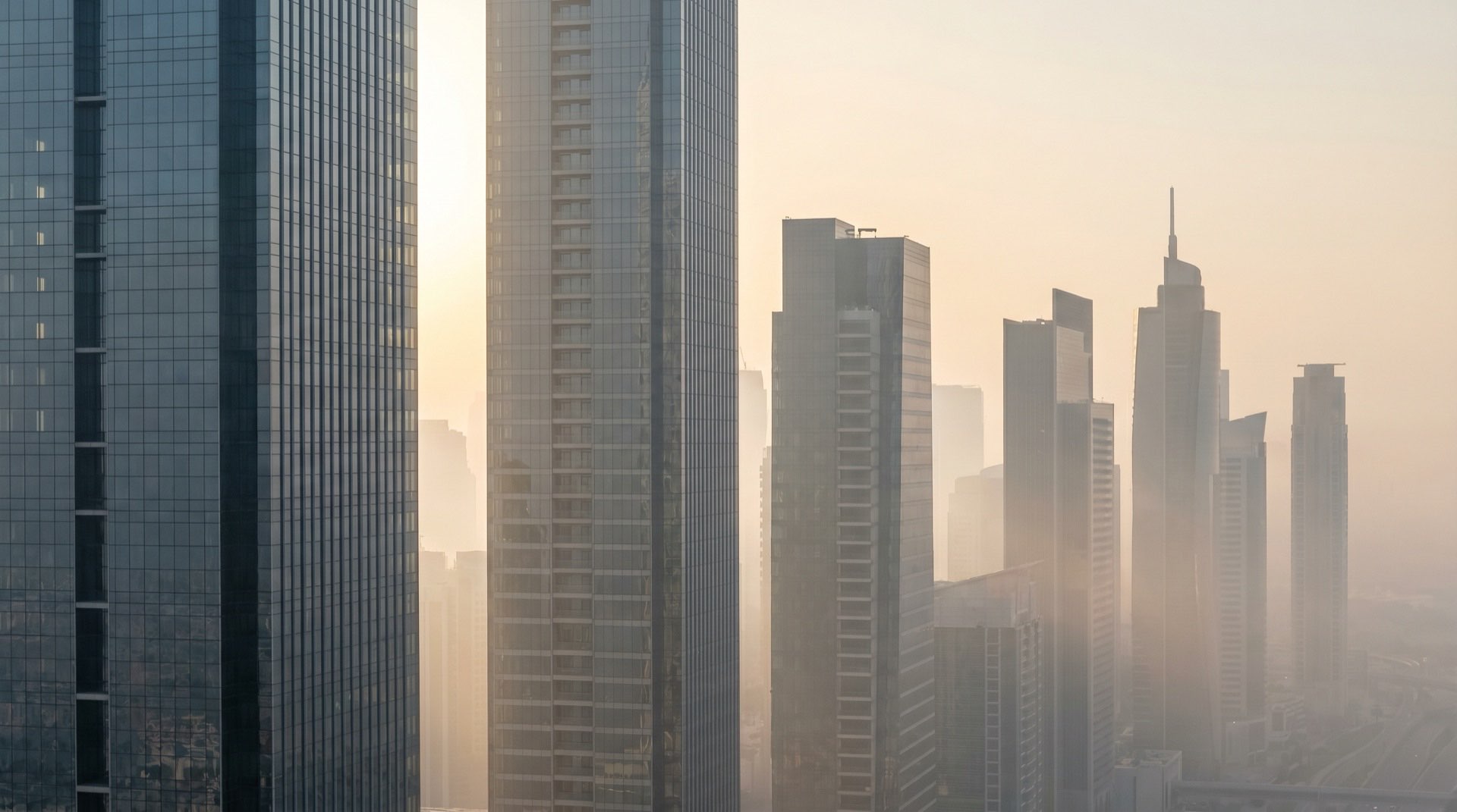 Moderner Wohnhochhaus in Dubai im goldenen Abendlicht, Glasfassade mit geometrischer Struktur
