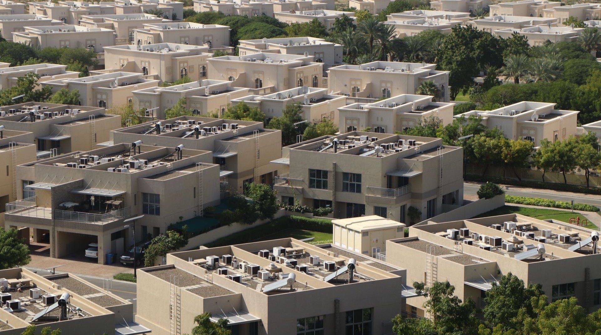 Mittelhohe Wohngebäude und Townhouses in Jumeirah Village Triangle, Dubai, im warmen Licht der späten Nachmittagssonne